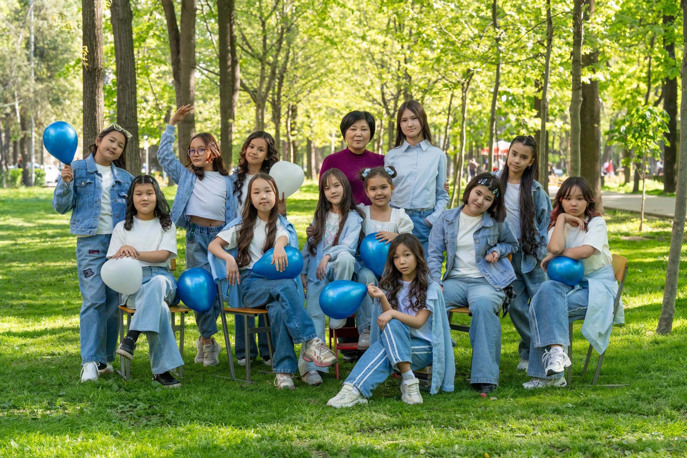 A junior class with a teacher among green trees