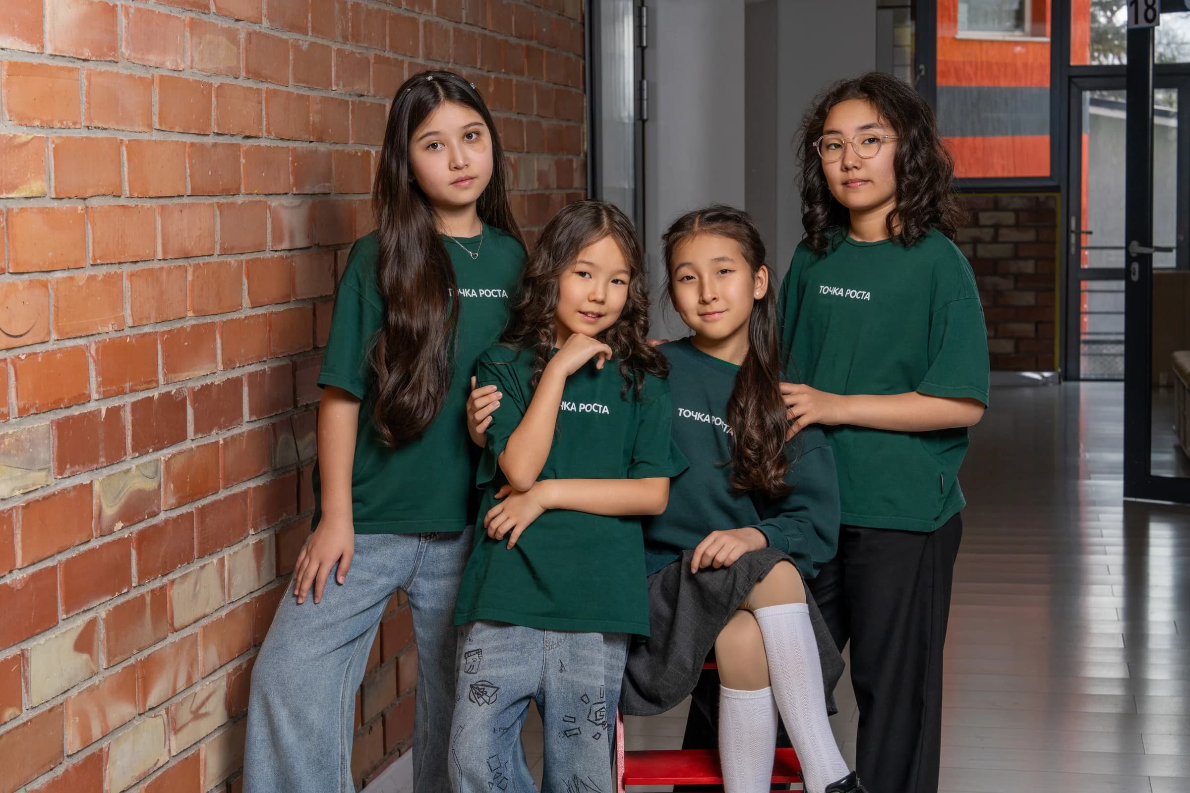 Four schoolgirls by a brick wall